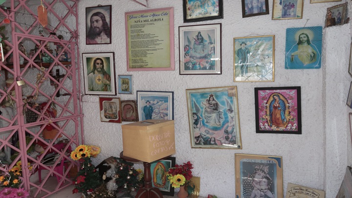 Los cientos de creyentes que acuden a donde están los restos de la pequeña Gloría María Alfonso le dejan fotos, placas, peluches y juguetes