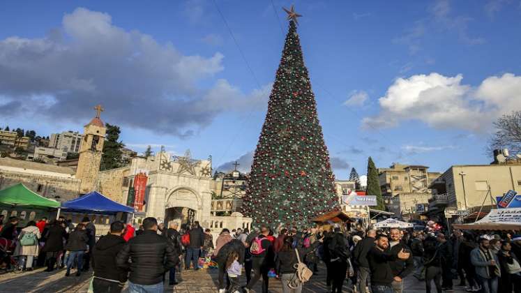 En el árbol de Navidad de Nazaret, numerosos judíos israelíes admiran un inmenso pino decorado con luces./AFP